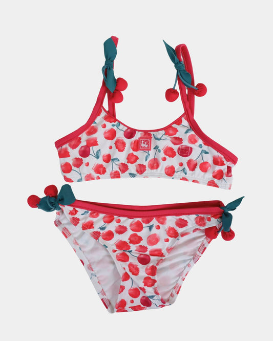 Al Agua Patos girls cherry print bikini with red trim, green bow ties, and pom-pom details